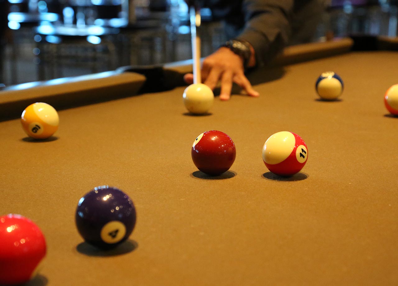 Bolas de bilhar na mesa de bilhar com as mãos e pau do jogador o conceito  de esportes e jogos de azar